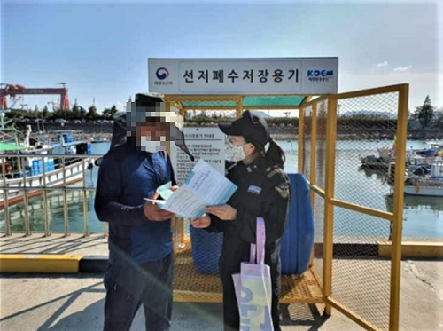 목포해경이 어업인을 상대로 홍보물을 배포하며 선저폐수 적법처리에 대해 안내하고 있다.png