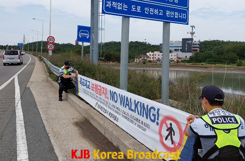 목포해경 북항파출소 경찰관이 목포대교 진입구간에 현수막을 설치하고 있다(2).png