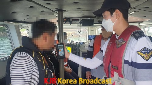 해양경찰관이 모터보트 조종자 상대 음주측정을 하고 있다..png