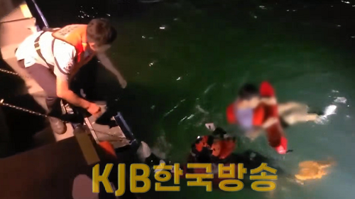 해양경찰이 갯바위 고립자를 해상으로 구조하고 있다.png