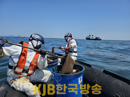 해양경찰이 유출된 기름띠 제거를 위해 유흡착포를 이용해 수거하고 있다.png